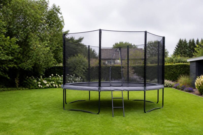 Trampoline met veiligheidsnet in een ruime achtertuin