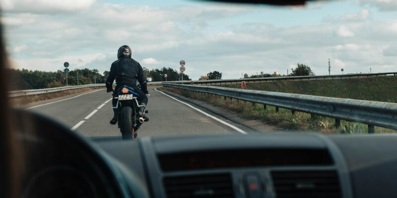 man in black jacket riding motorcycle on road during daytime